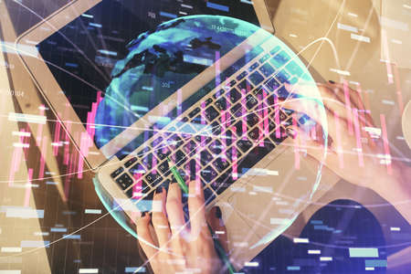 Double exposure of woman hands working on computer and forex chart hologram drawing. Top View....
