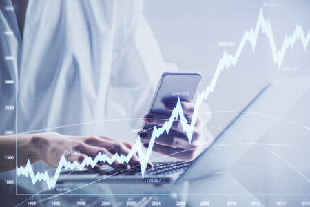 Double exposure of financial graph sketch hologram and woman holding and using a mobile device....