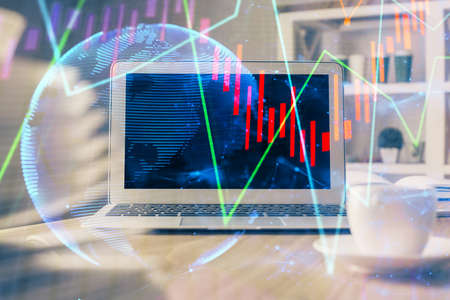 Forex market graph hologram and personal computer on background. Multi exposure. Concept of...