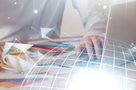Double exposure of world map hologram with man working on computer on background. Concept of...