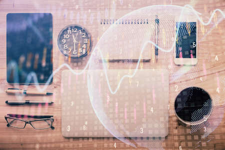 Double exposure of forex graph hologram over desktop with phone. Top view. Mobile trade platform...