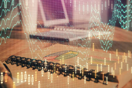 Double exposure of financial graph drawings and desk with open notebook background. Concept of forex...