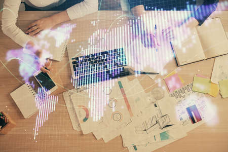 Double exposure of woman hands working on computer and financial theme hologram drawing. Top View. Business concept.の写真素材