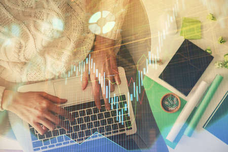 Multi exposure of woman hands working on computer and forex chart hologram drawing. Top View....