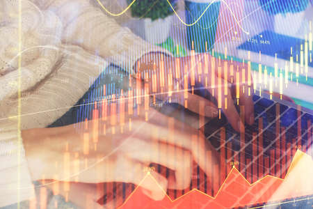 Double exposure of woman hands typing on computer and forex chart hologram drawing. Stock market...