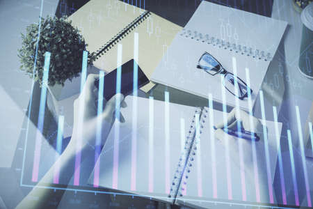 Multi exposure of woman on-line shopping holding a credit card and financial graph drawing. Stock...