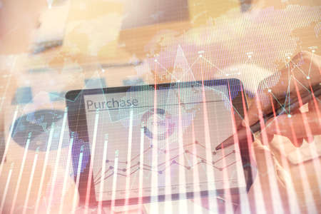 Double exposure of man's hands holding and using a phone and financial chart drawing. Market...