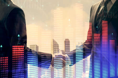 Double exposure of forex graph hologram and handshake of two men. Stock market concept.