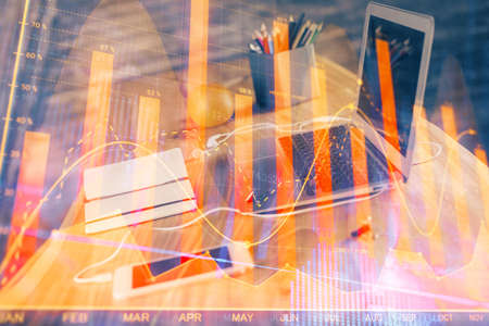 Stock market chart hologram drawn on personal computer background. Double exposure. Concept of investment.の写真素材