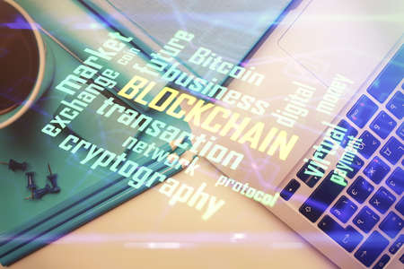 Blockchain theme hologram drawings over computer on the desktop background. Top view. Multi exposure. Concept of cryptoeconomy.の写真素材