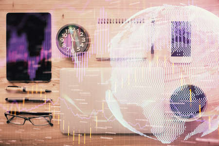 Double exposure of forex graph hologram over desktop with phone. Top view. Mobile trade platform concept.の写真素材