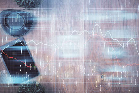 Multi exposure of financial chart hologram over desktop with phone. Top view. Mobile trade platform...