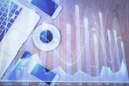 Multi exposure of financial chart hologram over desktop with phone. Top view. Mobile trade platform...