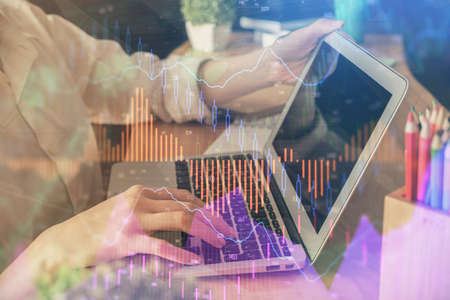 Double exposure of woman hands typing on computer and forex chart hologram drawing. Stock market...