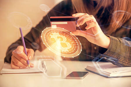 Multi exposure of woman on-line shopping holding a credit card and crypto theme drawing. Blockchain...