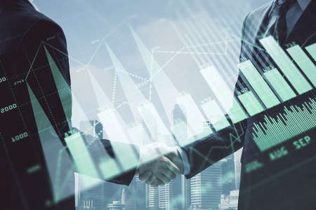 Double exposure of forex graph hologram and handshake of two men. Stock market concept.の写真素材