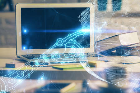 Computer on desktop in office with technology theme hologram. Double exposure. Tech concept.