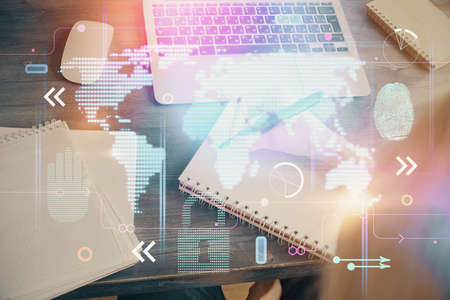 Double exposure of hands making notes with world map hologram and data theme icons. Concept of...