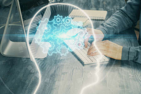 Man typing on keyboard background with brain hologram. Concept of big Data. Double exposure.