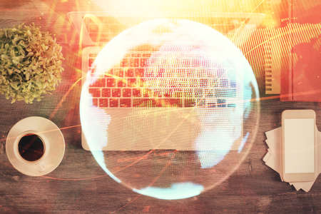Business theme hologram drawings over computer on the desktop background. Top view. Multi exposure....