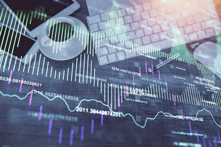 Double exposure of forex chart hologram over desktop with phone. Top view. Mobile trade platform...