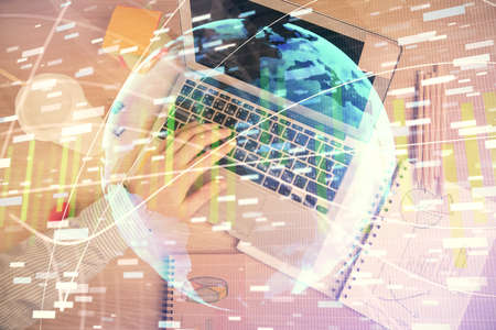 Double exposure of man's hands typing over computer keyboard and business theme hologram drawing....