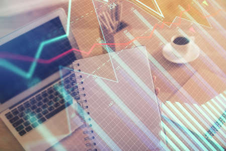 Double exposure of businesswoman hands typing on computer and forex chart hologram drawing....