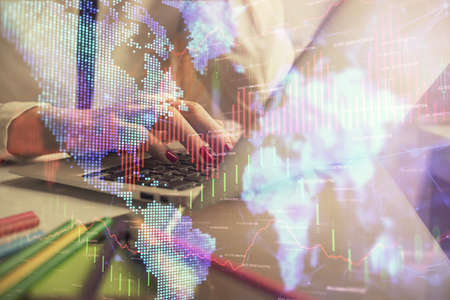 Double exposure of woman hands typing on computer and financial graph hologram drawing. Stock market...