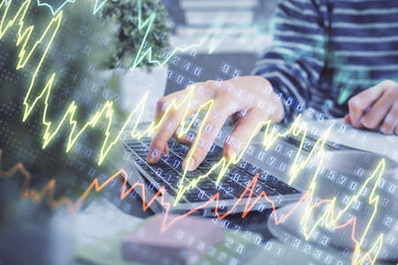 Double exposure of woman hands typing on computer and forex chart hologram drawing. Stock market...