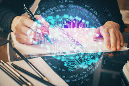 Double exposure of writing hand on background with brain hologram. Concept of learning.