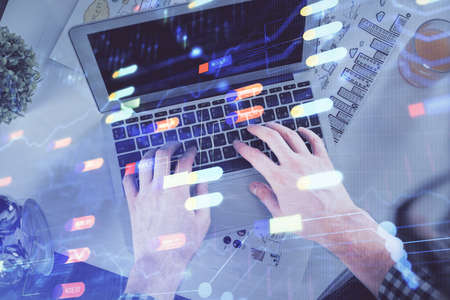 Multi exposure of man's hands typing over computer keyboard and data theme hologram drawing. Top...