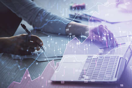 Double exposure of businesswoman hands typing on computer and forex chart hologram drawing....