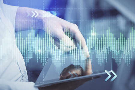 Double exposure of man's hands holding and using a digital device and forex graph drawing. Financial...