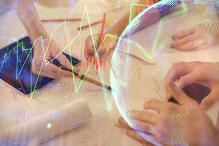 Double exposure of forex graph drawing and man and woman working together holding and using a mobile...