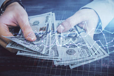 Multi exposure of financial graph drawing hologram and USA dollars bills and man hands. Analysis...