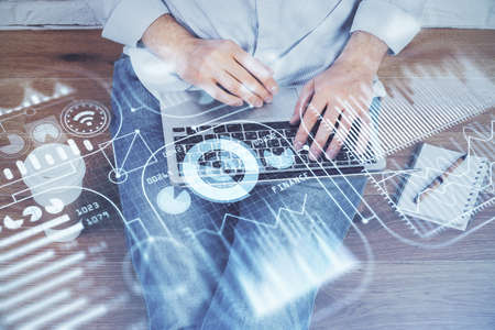 Technology theme hologram with man working on computer on background. High tech concept. Multi...