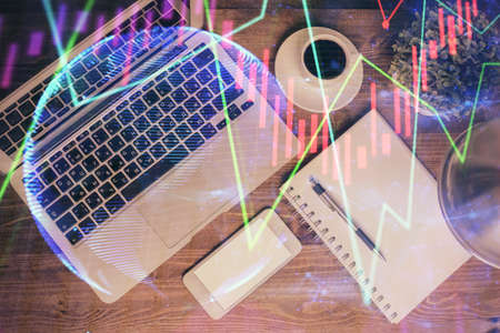 Financial market graph and top view computer on the desktop background. Double exposure. Investment concept.の写真素材
