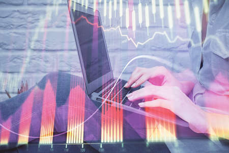 Multi exposure of woman hands typing on computer and forex chart hologram drawing. Stock market...
