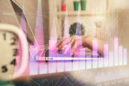 Double exposure of woman hands typing on computer and forex chart hologram drawing. Stock market...