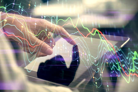 Multi exposure of man's hands holding and using a phone and financial chart drawing. Market analysis...