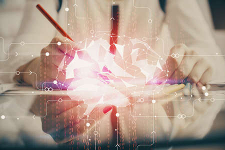 Multi exposure of woman's writing hand on background with brain hud. Concept of learning.