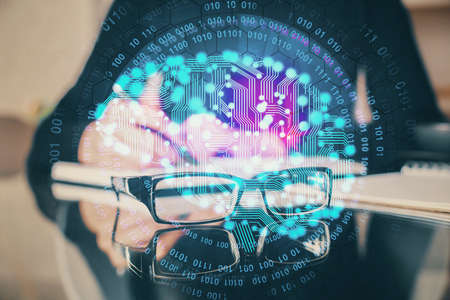 Double exposure of writing hand on background with brain hologram. Concept of learning.