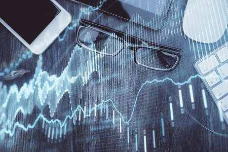 Multi exposure of forex graph hologram over desktop with phone. Top view. Mobile trade platform...