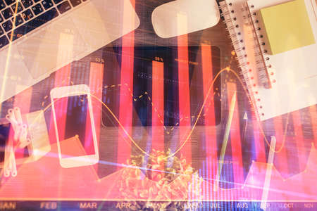 Double exposure of forex chart hologram over desktop with phone. Top view. Mobile trade platform...