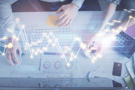 Double exposure of man and woman working together and financial chart hologram drawing. market...