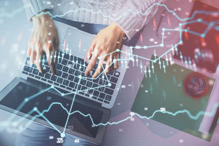 Multi exposure of woman hands working on computer and forex chart hologram drawing. Top View....
