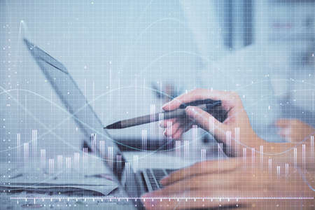 Multi exposure of woman hands typing on computer and financial graph hologram drawing. Stock market...
