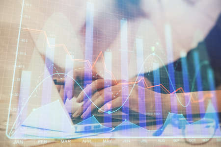 Multi exposure of woman hands typing on computer and financial graph hologram drawing. Stock market...