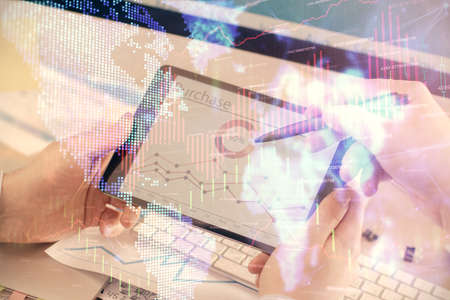 Double exposure of man's hands holding and using a phone and financial chart drawing. Market...