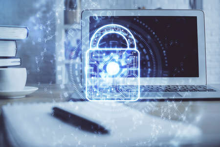 Double exposure of desktop with computer and lock icon hologram. Concept of data safety.の写真素材